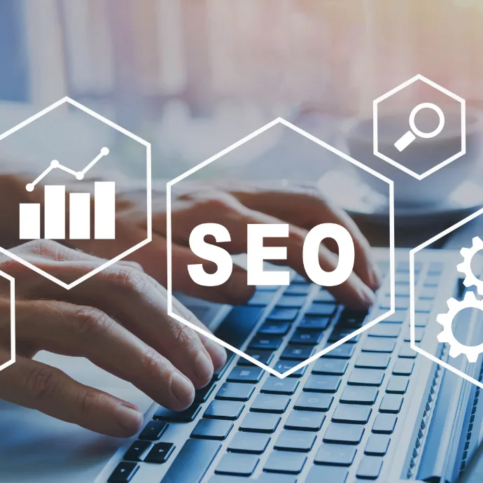 Mengetik di laptop dengan ikon SEO, pencarian, dan grafik